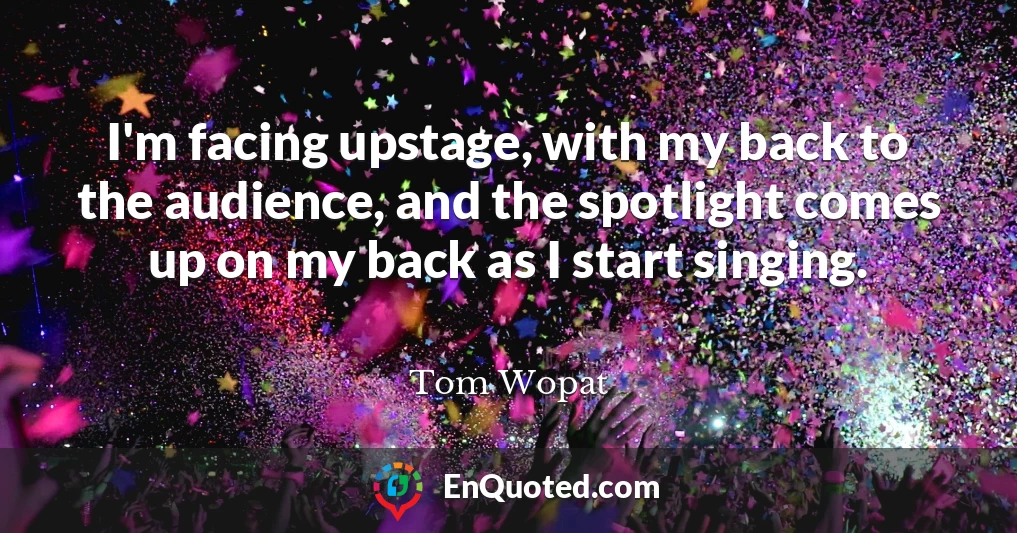 I'm facing upstage, with my back to the audience, and the spotlight comes up on my back as I start singing.